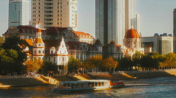European-style buildings along the Haihe River in Tianjin with a sightseeing boat passing by.