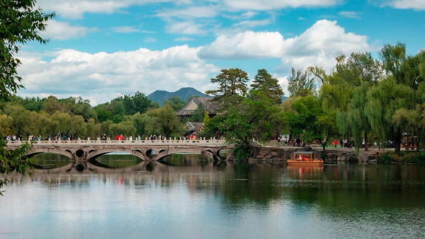 Scenic view of Chengde’s imperial garden bridge surrounded by willow trees and calm lake waters, showcasing Hebei’s natural beauty and cultural heritage.