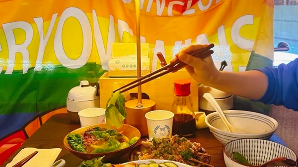 A cozy noodle shop in China with a big rainbow flag that says "Everyone is included" — a queer-friendly local restaurant supporting LGBTQ+ Pride.