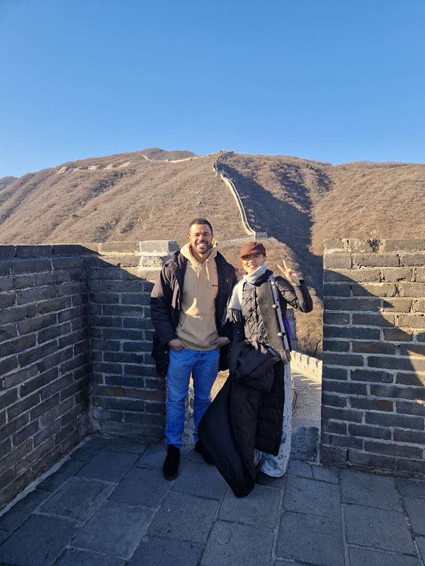 Smiling people posing at a scenic section of the Great Wall near Beijing, adding a cultural highlight to the local resident experience