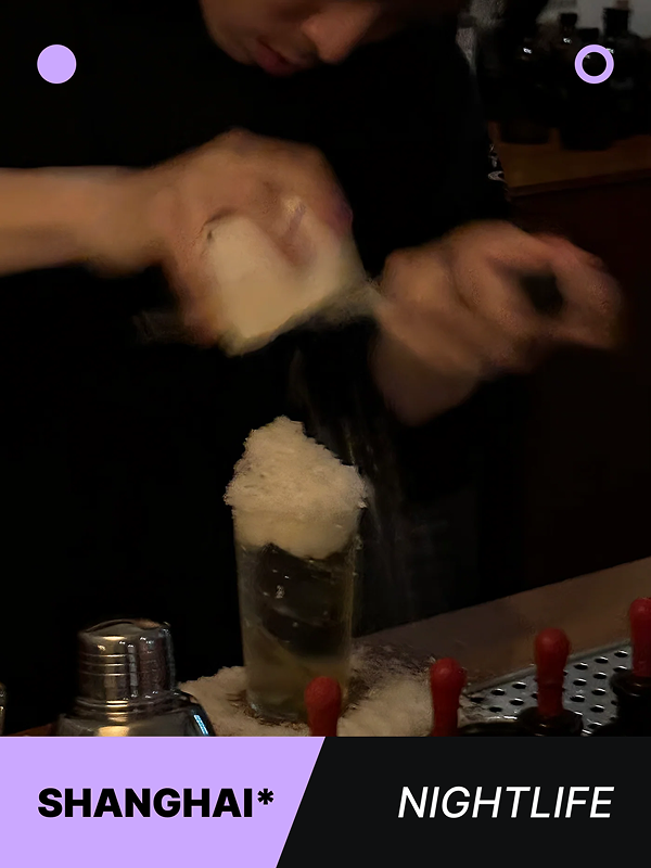 Bartender preparing a creative cocktail with ice at a bar counter, showcasing mixology skills.