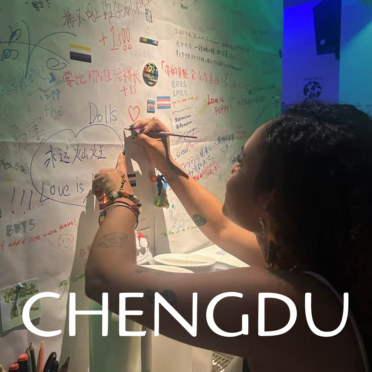 A traveler writing on a colorful graffiti wall in Chengdu, highlighting creative and interactive local experiences.