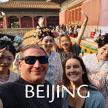 A group of tourists posing joyfully at the Forbidden City, showcasing cultural experiences in Beijing.