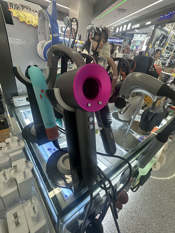 Close-up of colorful handheld hair dryers displayed in a Shenzhen tech shop