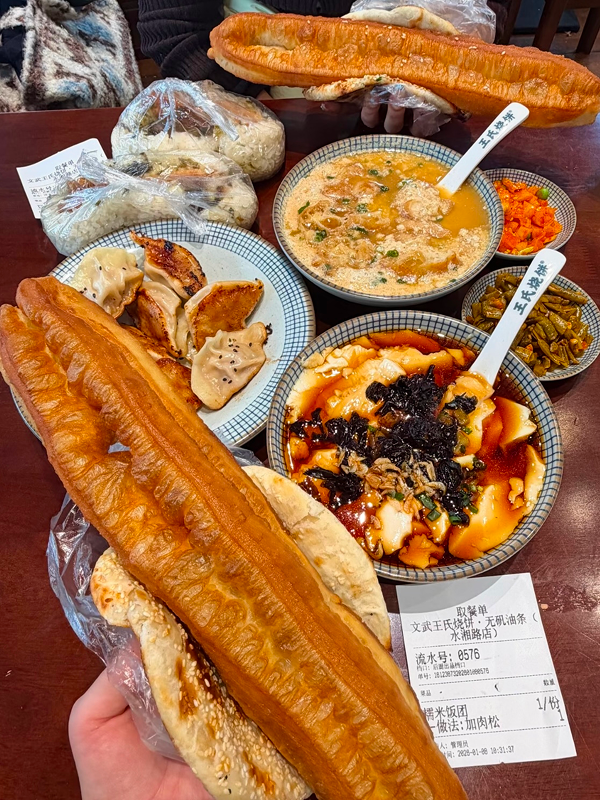 Full Hangzhou breakfast spread with youtiao, douhua, soy milk, and savory toppings