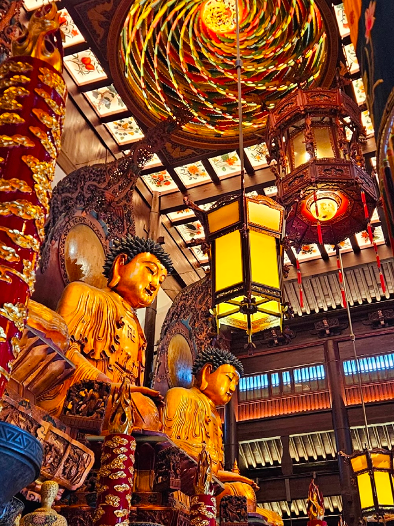 Ornate Buddhist statues and lanterns inside Jade Buddha Temple main hall in Shanghai