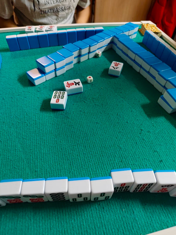 Close-up of a traditional mahjong game in progress on a green felt table in Chengdu, reflecting real-time strategy and gameplay