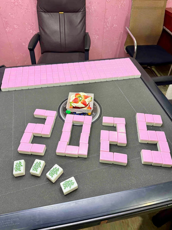 Mahjong tiles creatively arranged to form “2025” with a fruit cake in the center, celebrating the game in a festive Chengdu setting