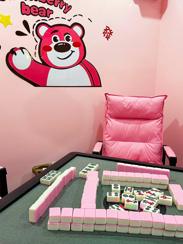A colorful Beijing mahjong room with pink tiles and cute cartoon wall art, offering a fun twist on traditional Chinese gaming