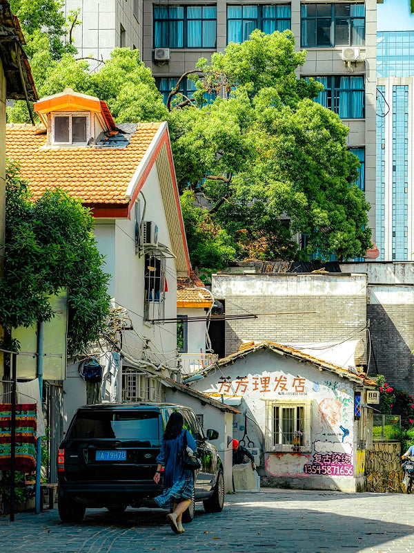 Narrow residential alley in Wuhan with a small neighborhood barber shop and traditional tiled rooftops, revealing daily local life