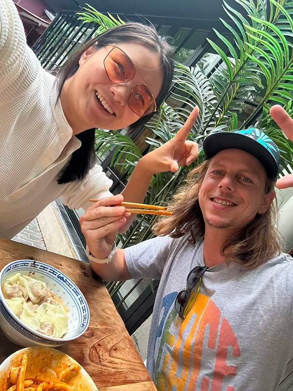 Local Chengdu resident and visitor sharing dumplings at a street-side eatery, capturing authentic food culture and hospitality