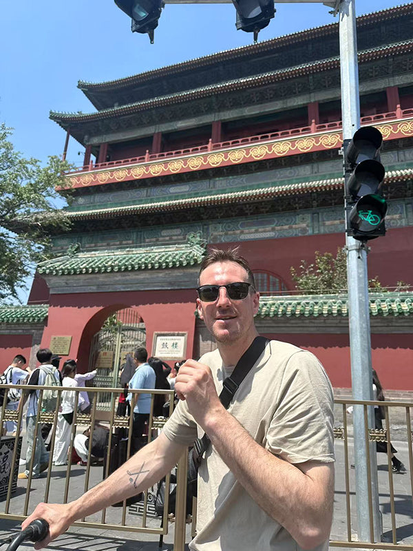 Traveler standing in front of the iconic Drum Tower in central Beijing, a must-visit historical site in neighborhood exploration