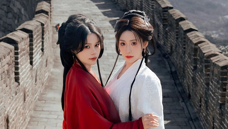 Two girls wearing traditional clothing ascend the Great Wall.