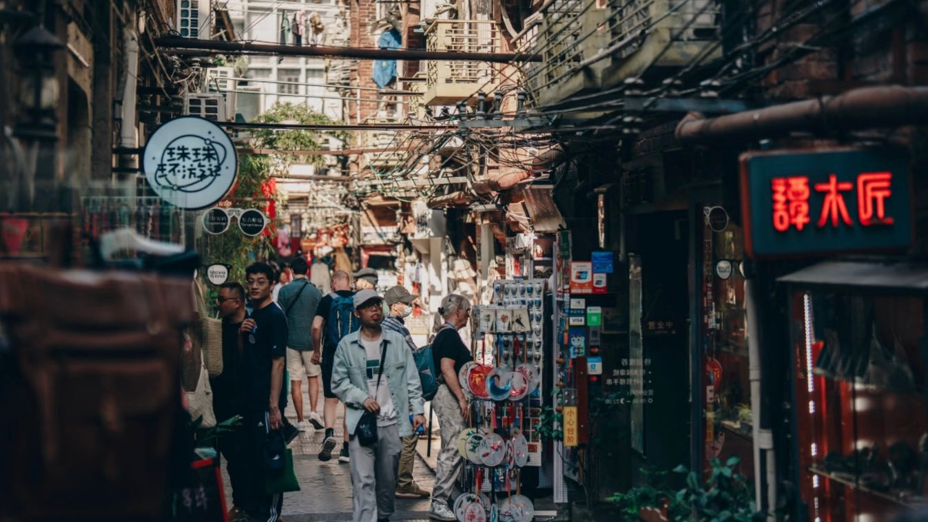 Bustling alley in Tianzifang, Shanghai, filled with tourists exploring local shops, art studios, and handmade souvenir stands in a traditional shikumen setting.