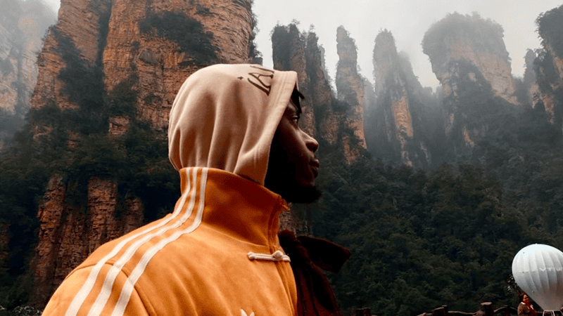 A French tourist in neo-Chinese attire explores Zhangjiajie National Forest Park.