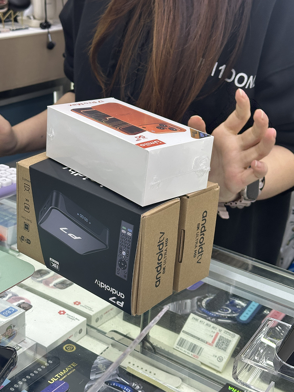 Smartphone boxes and tech products displayed on shop counter during Shenzhen shopping walk