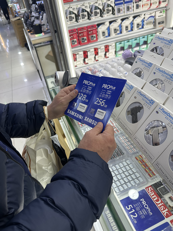 Shopper holding SIM cards and mobile accessories inside Shenzhen Huaqiangbei mall
