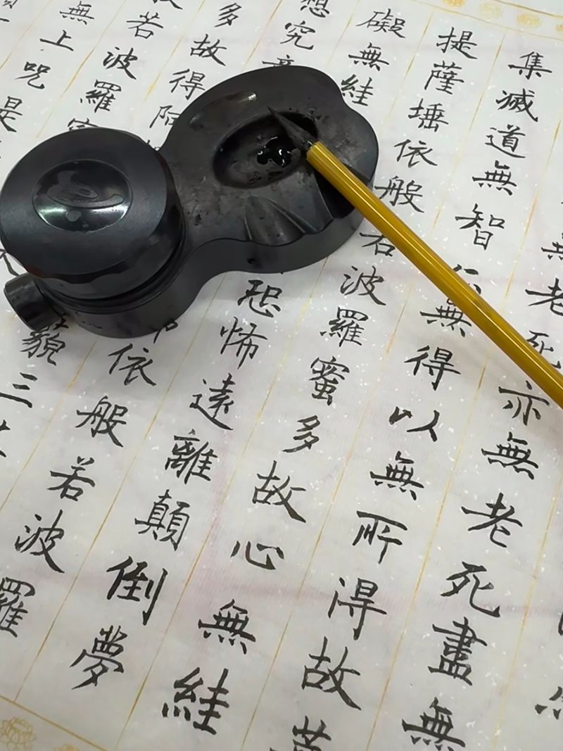 Traditional Chinese calligraphy tools with ink stone and brush on Hanzi practice sheet
