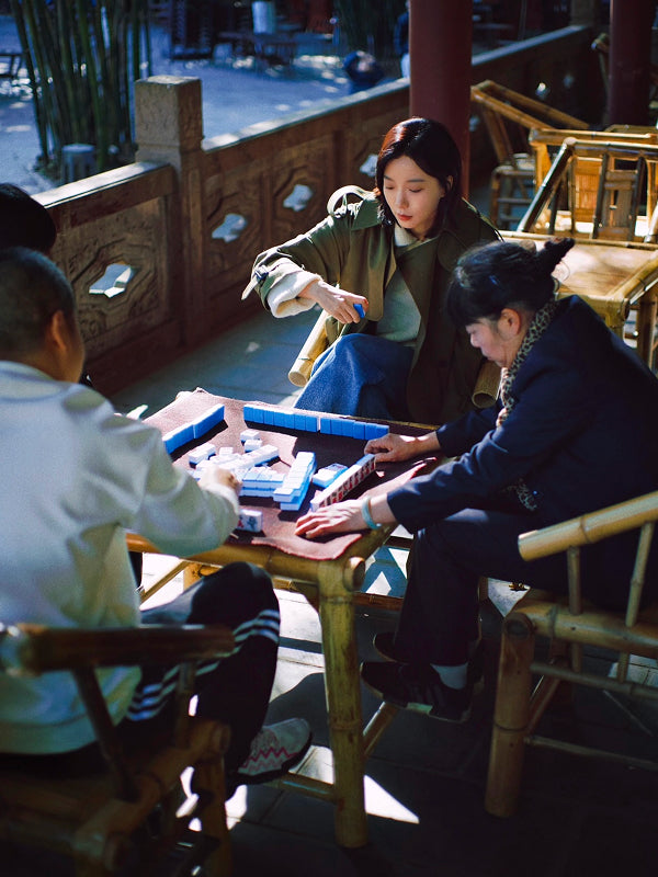 Local Chengdu residents playing mahjong in a serene courtyard setting, showcasing authentic Chinese leisure culture