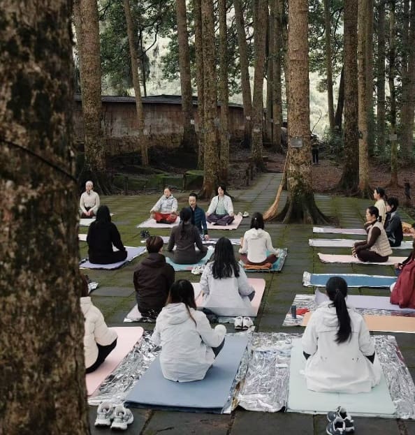 Women gather in meditation at a temple during an International Women's Day event, finding stillness and connection in sacred space.