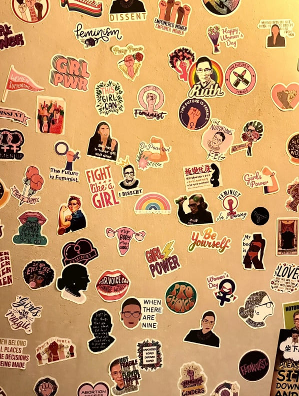 A corner of a feminist-only bar, covered wall to wall with feminist slogan stickers.